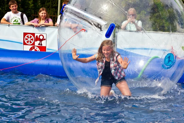 Meninas e meninos se divertir em uma enorme bola zorbing — Fotografia de Stock