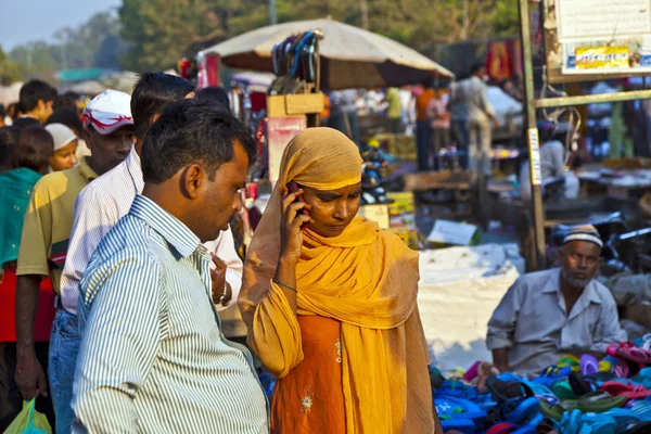 Vrouw met behulp van de mobiele telefoon in de meena bazaar in delhi — Stockfoto
