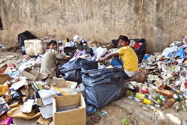 Scarso lavoratore che controlla la spazzatura per plastica e carta per rifiuti se — Foto Stock
