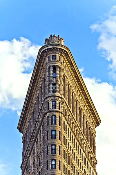 Facade of the Flatiron building with iron statue of Man on the — Stock Photo, Image