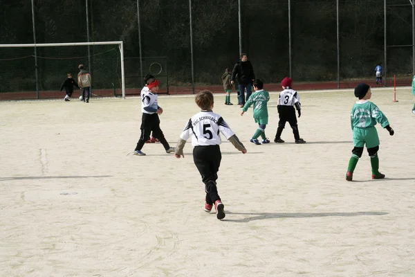 Crianças jogando futebol no inverno em uma arena ao ar livre — Fotografia de Stock