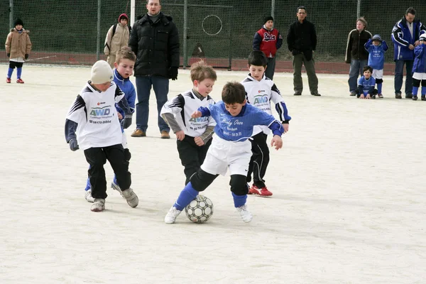 Niños jugando al fútbol en invierno en una arena al aire libre — Foto de Stock