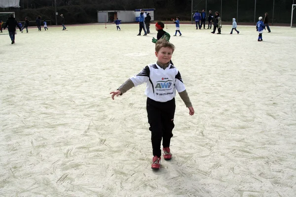 Barn spelar fotboll på vintern på en utomhus arena — Stockfoto