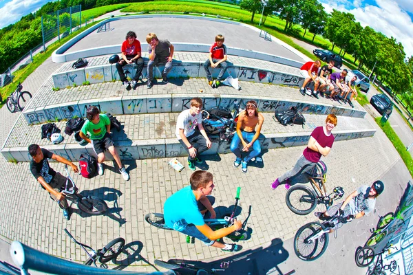 Meninos em um parque de skate assistindo outros motociclistas e se divertindo — Fotografia de Stock