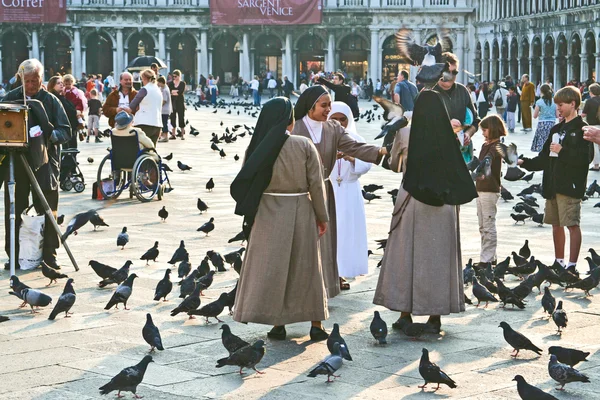 Ourists 산 마르코 광장에 비둘기의 큰 무리를 먹이 — 스톡 사진