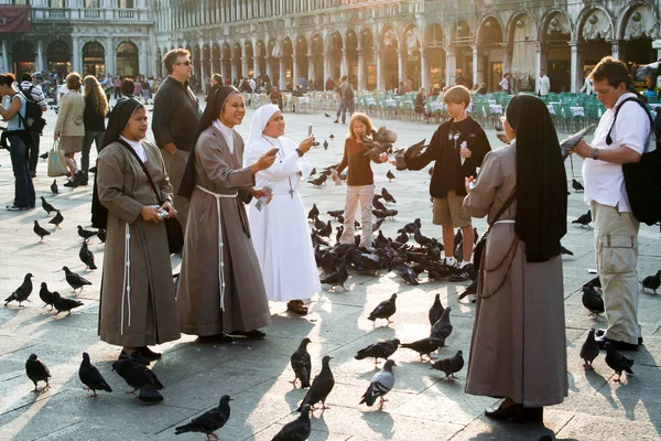 Nons auf dem san marco platz füttern große taubenschar — Stockfoto