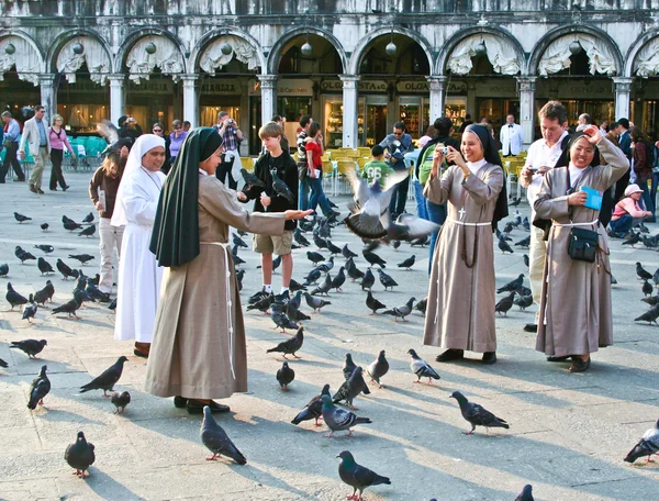 Nons auf dem san marco platz füttern große taubenschar — Stockfoto