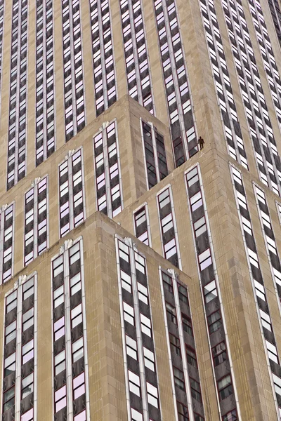 Fasad av skyskrapa med statyn av man — Stockfoto