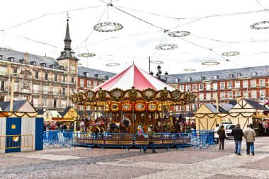 Carousell for children in the evening at the plaza de Mayor in M clipart