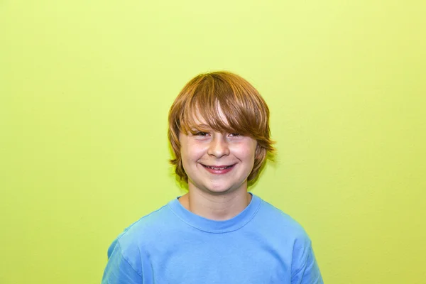 Gelukkig glimlachen jong jongen met gele muur — Stockfoto