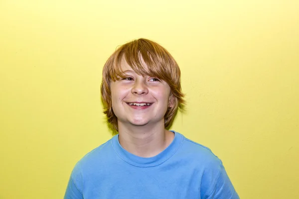 Feliz niño sonriente con la pared amarilla —  Fotos de Stock