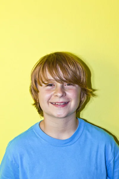 Feliz sorrindo menino com parede amarela — Fotografia de Stock
