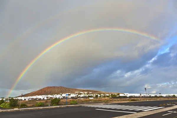 Belo arco-íris sobre a montanha com nuvens escuras — Fotografia de Stock