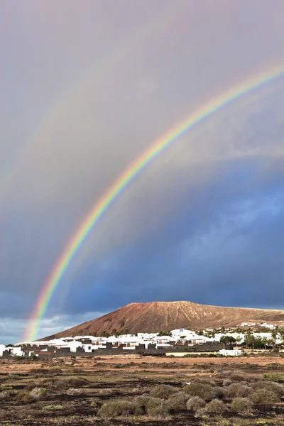 Stock image Beautiful rainbow over the mountain with dark clouds