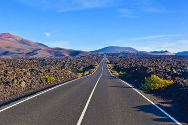 timanfaya Milli Parkı içinde kayalar arasındaki yol