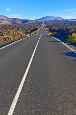 timanfaya Milli Parkı içinde kayalar arasındaki yol