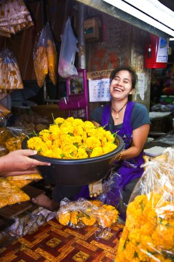 Women are selling fresh flowers at the morning market clipart