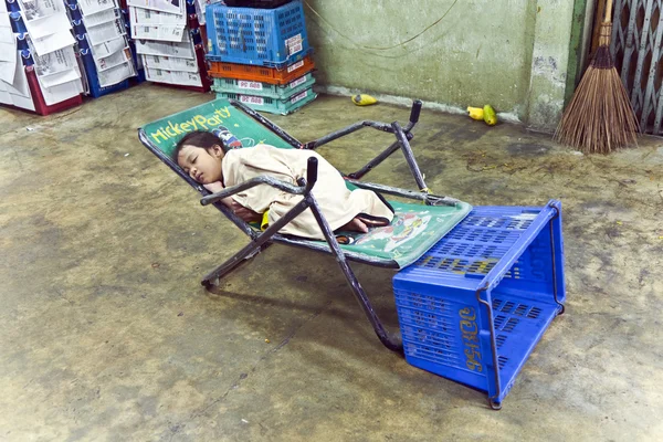 Neidentifikovaný mladá dívka spí v obchodě květinového trhu — Stock fotografie