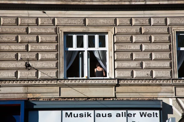 Žena stojící u okna, ale hledá uvnitř — Stock fotografie