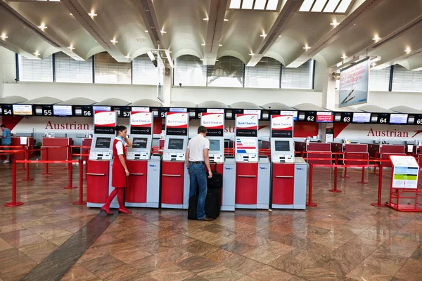 Hostess is helping a passenger at the Self Check in at viennas A — Stock Photo, Image