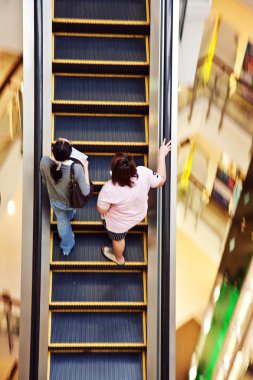 Bangkok'ta merkez alışveriş merkezinde hareketli merdiven kullanan kadın