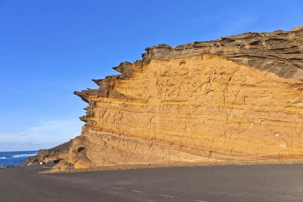 Vulkanické ledvinových kamenů s modrou oblohou v el golfo, lanzarote — Stock fotografie