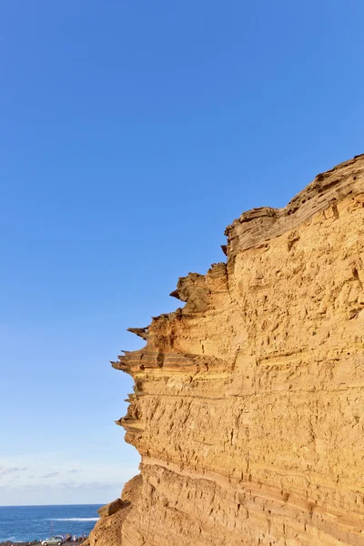 Vulkanické ledvinových kamenů s modrou oblohou v el golfo, lanzarote — Stock fotografie