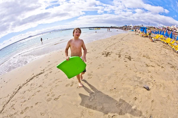 Niño con tabla de surf en la playa —  Fotos de Stock