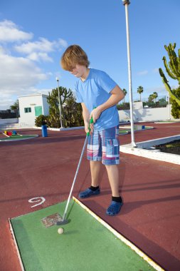 Mini golf sahası içinde oynayan çocuk