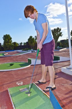 Mini golf sahası içinde oynayan çocuk