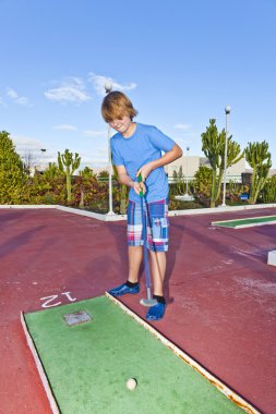 Mini golf sahası içinde oynayan çocuk