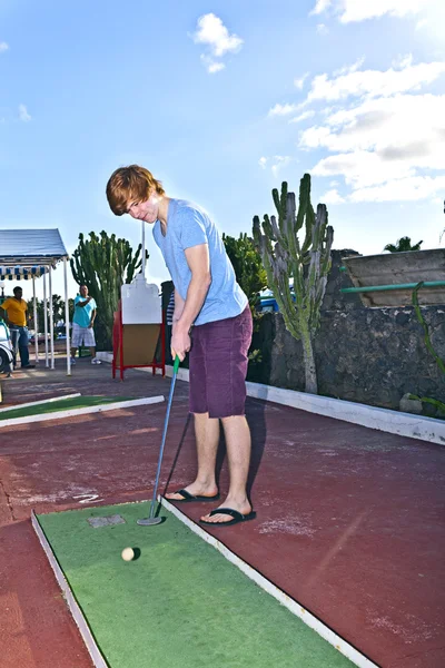 Chłopiec gry w mini golfa w trakcie — Zdjęcie stockowe
