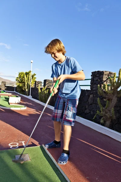 Niño jugando mini golf en el campo — Foto de Stock
