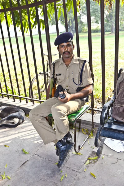 Policista věnuje pozornost v červené pevnosti chrání návštěvníků — Stock fotografie