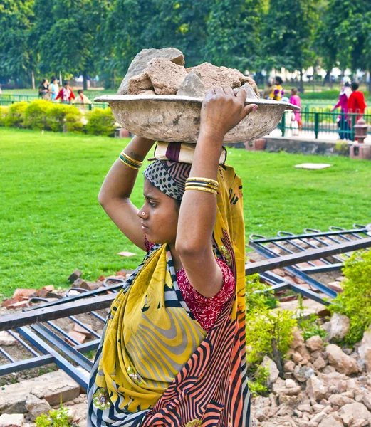 Female worker carries rock waste on her hat — Stock Photo, Image