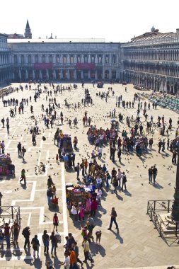 Tourists on San Marco square feed large flock of pigeons clipart