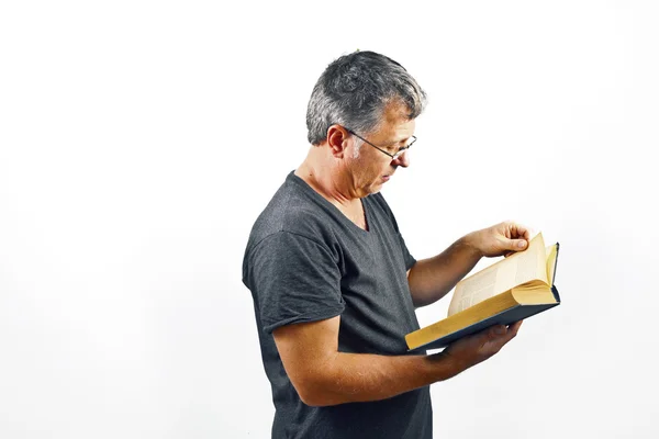 Homme avec des lunettes de lecture dans un livre — Photo