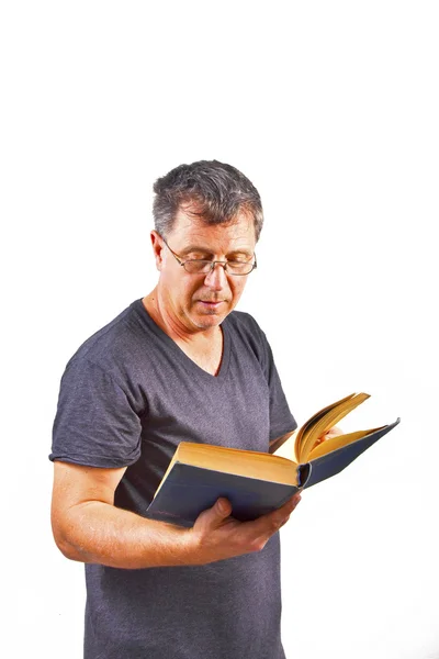 Homem com óculos lendo em um livro — Fotografia de Stock