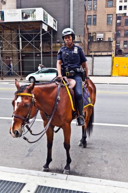 Policeofficer is riding his horse downtown New York clipart