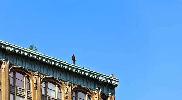 Elewacji budynków w godzinach popołudniowych z żelaza człowiek statua o powrotem — Zdjęcie stockowe