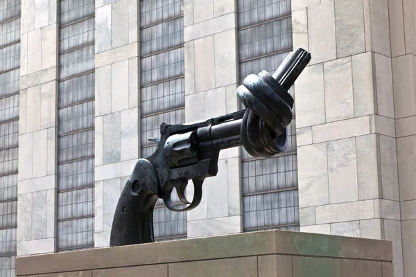 Gun tied in a knot outside UN headquarters as symbol for reachin — Stock Photo, Image
