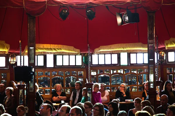 観客は読書にテントの中で著者を聞いています。 — ストック写真