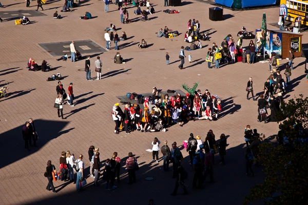 Isitors zitten in de zon buiten op de enorme eerlijke plaats — Stockfoto