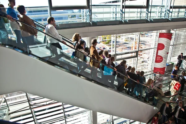 Visitors inside the fair hall on moving staircase — Stock Photo, Image