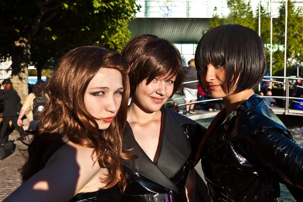 Tři dívky v černém v kostýmech, které jsou homologní k photografers — Stock fotografie