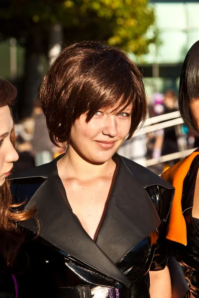 Tre flickor i svart i kostymer poserar för fotografer — Stockfoto