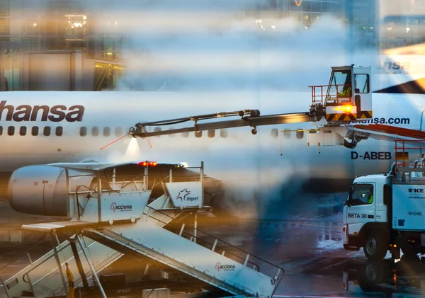 Worker deices the wing of the plain in Frankfurt airport — Stock Photo, Image