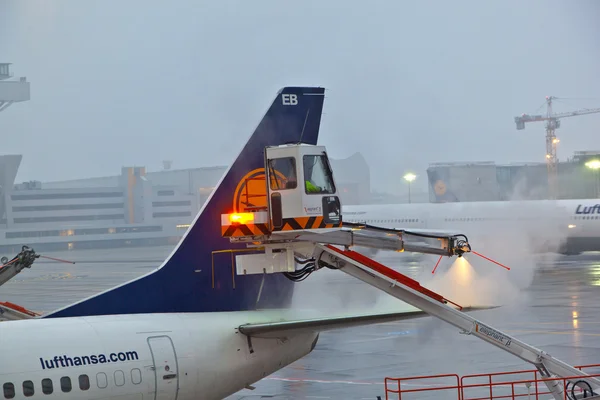 Werknemer deices de vleugel van de vlakte in frankfurt luchthaven — Stockfoto