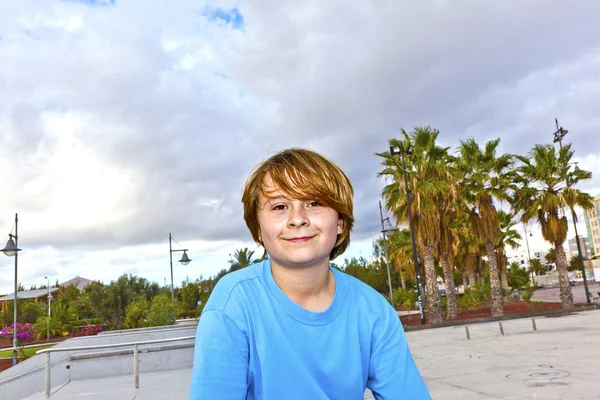 Šťastný chlapec s koloběžkou na skateparku — Stock fotografie