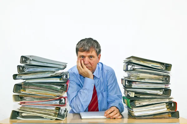 Mann studiert Ordner mit Akten am Schreibtisch im Büro — Stockfoto